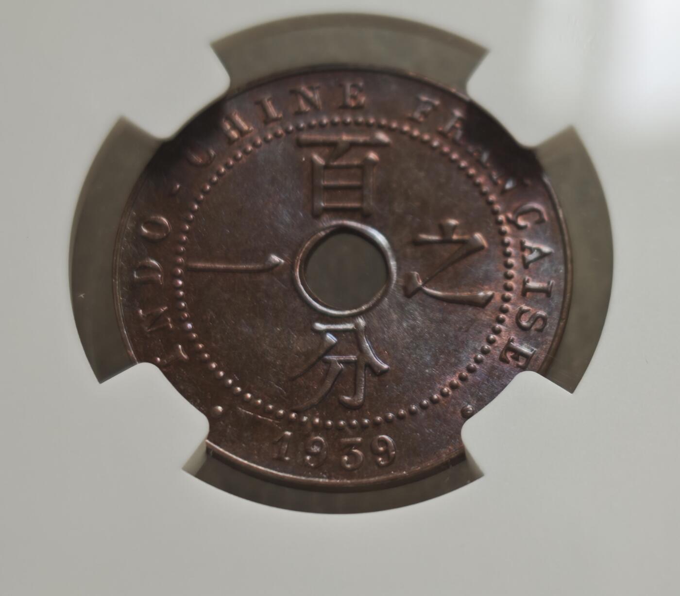 瓶子🏺第236期拍卖会  法属印度支那（French Indochina，今越南、老挝、柬埔寨地区）于1939年发行的百分之一分（1 Cent）圆孔铜币，由国际顶级钱币评级机构NGC（Numismatic Guaranty Company）评级为 MS 63 BN