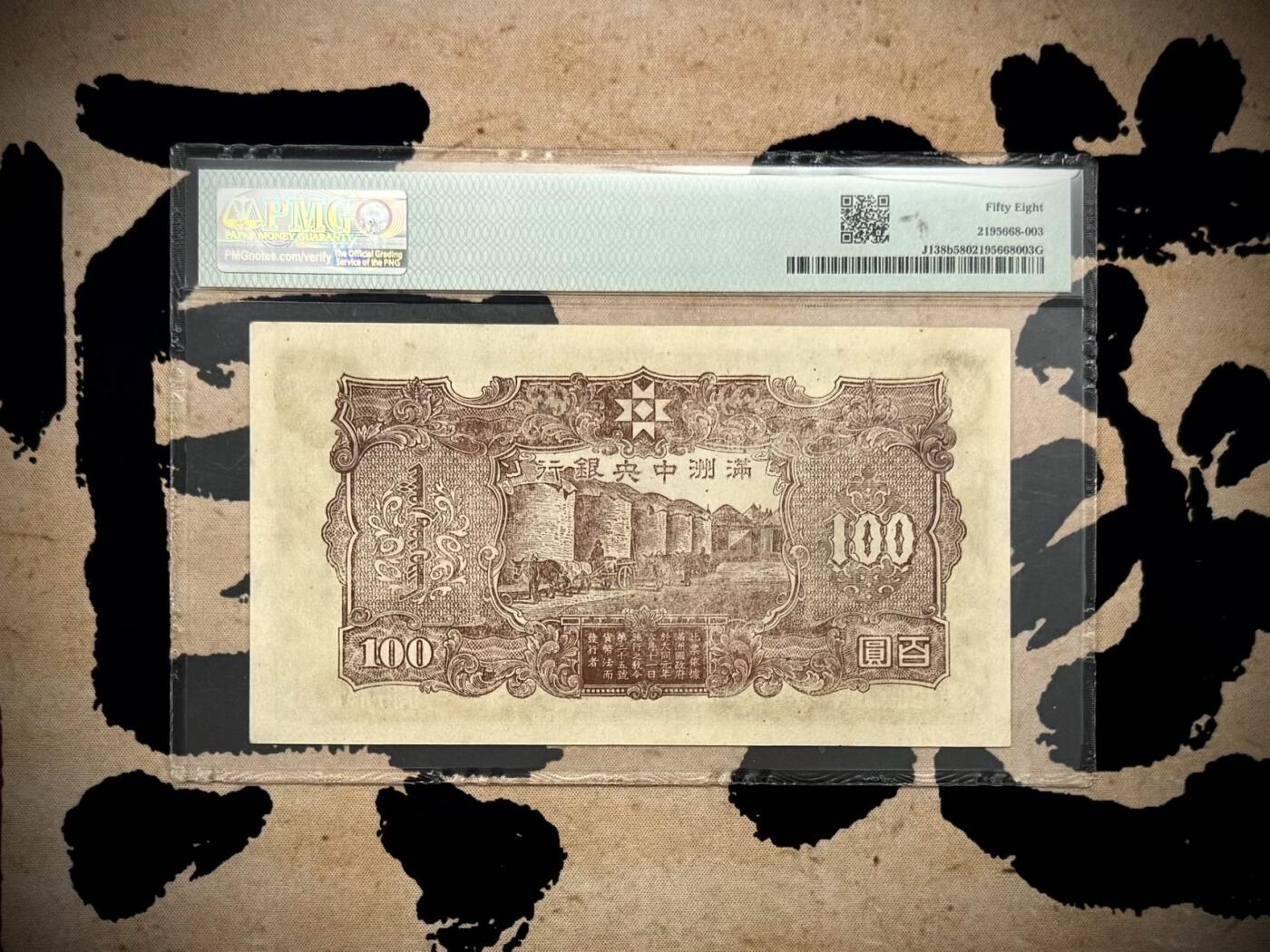 【乾奕收藏】出民国33年1944年满洲中央银行百圆，号码全程无47，正面孔子大殿，同分数里居中度较优秀的一枚，背面粮仓图案，美国PMG58分，民国纸币经过80年能保存如此品相实属难得，喜欢的老板不要错过，评级币一切以分数为准，售出非假不退
