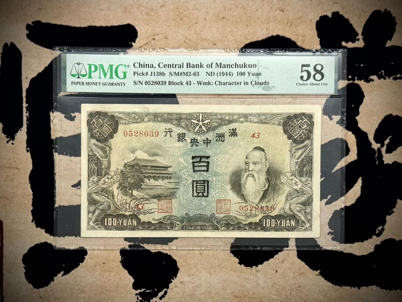 （自动截拍）PMG评级民国纸币专拍第20260407期，全场包邮 【乾奕收藏】出民国33年1944年满洲中央银行百圆，号码全程无47，正面孔子大殿，同分数里居中度较优秀的一枚，背面粮仓图案，美国PMG58分