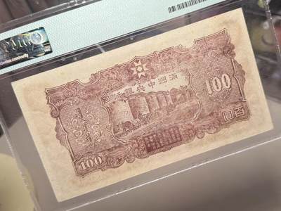 （自动截拍）PMG评级民国纸币专拍第20260424期，全场包邮 【乾奕收藏】出民国33年1944年满洲中央银行百圆，号码全程无47，正面孔子大殿，同分数里居中度较优秀的一枚，背面粮仓图案，美国PMG58分