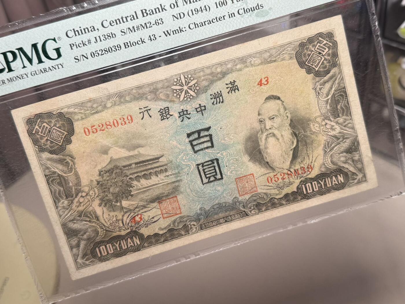 【乾奕收藏】出民国33年1944年满洲中央银行百圆，号码全程无47，正面孔子大殿，同分数里居中度较优秀的一枚，背面粮仓图案，美国PMG58分，民国纸币经过80年能保存如此品相实属难得，喜欢的老板不要错过，评级币一切以分数为准，售出非假不退