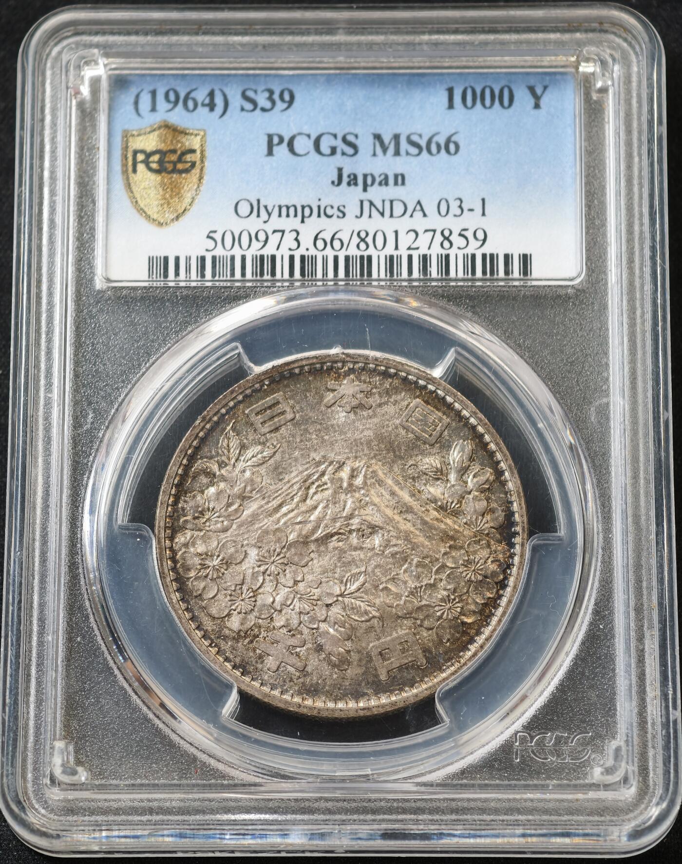 甄臻铺-世界币章拍卖（第59期），甄品场拍品征集中，送拍享返佣金等优惠多多 PCGS-MS66，日本1964年奥运银币，日本大奥1000日元，带官网高清大图，红绿蓝五彩渐变。盒子正面一处裂纹，表面光滑不影响密封