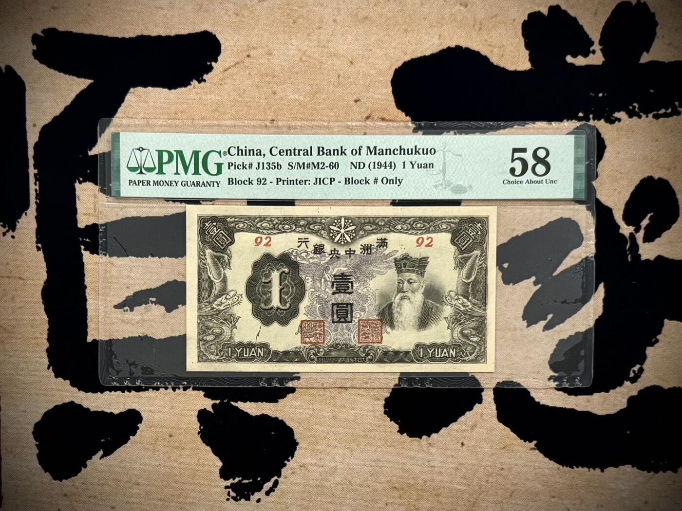 （自动截拍）PMG评级民国纸币专拍第20260411期，全场包邮 【乾奕收藏】出民国33年1944年满洲中央银行孔子像壹圆，紫凤图案，92短号，美国PMG58分