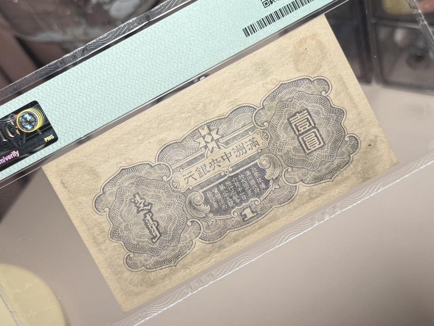 （自动截拍）PMG评级民国纸币专拍第20260411期，全场包邮 【乾奕收藏】出民国33年1944年满洲中央银行孔子像壹圆，紫凤图案，92短号，美国PMG58分