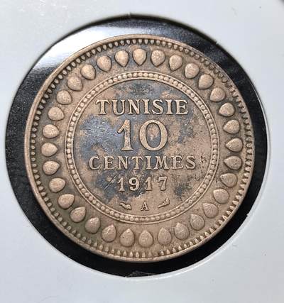 外国优质老铜币纪念币银币专场，周六晚上九点倒数截拍，满百包邮，周日发货,可寄存半年，喜欢朋友微信扫描二维码可直接参拍 - 法属突尼斯1917年10生丁铜币。正面为法语面值，背面是阿拉伯文铭文与橄榄枝，沿用法式钱币设计并融入阿拉伯文元素，是法属北非钱币体系的经典代表，也是近代殖民史的实物佐证。