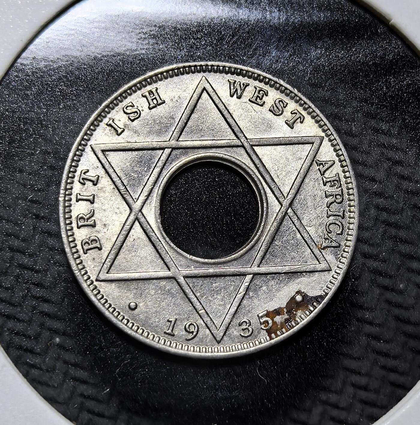 外国优质老铜币纪念币银币专场，周六晚上九点倒数截拍，满百包邮，周日发货,可寄存半年，喜欢朋友微信扫描二维码可直接参拍 英属西非1935年1/10 便士镍币，正面为英王乔治五世像，背面以所罗门之星（六芒星）为设计，是英属西非殖民地流通辅币，见证英国殖民西非的货币体系与历史。