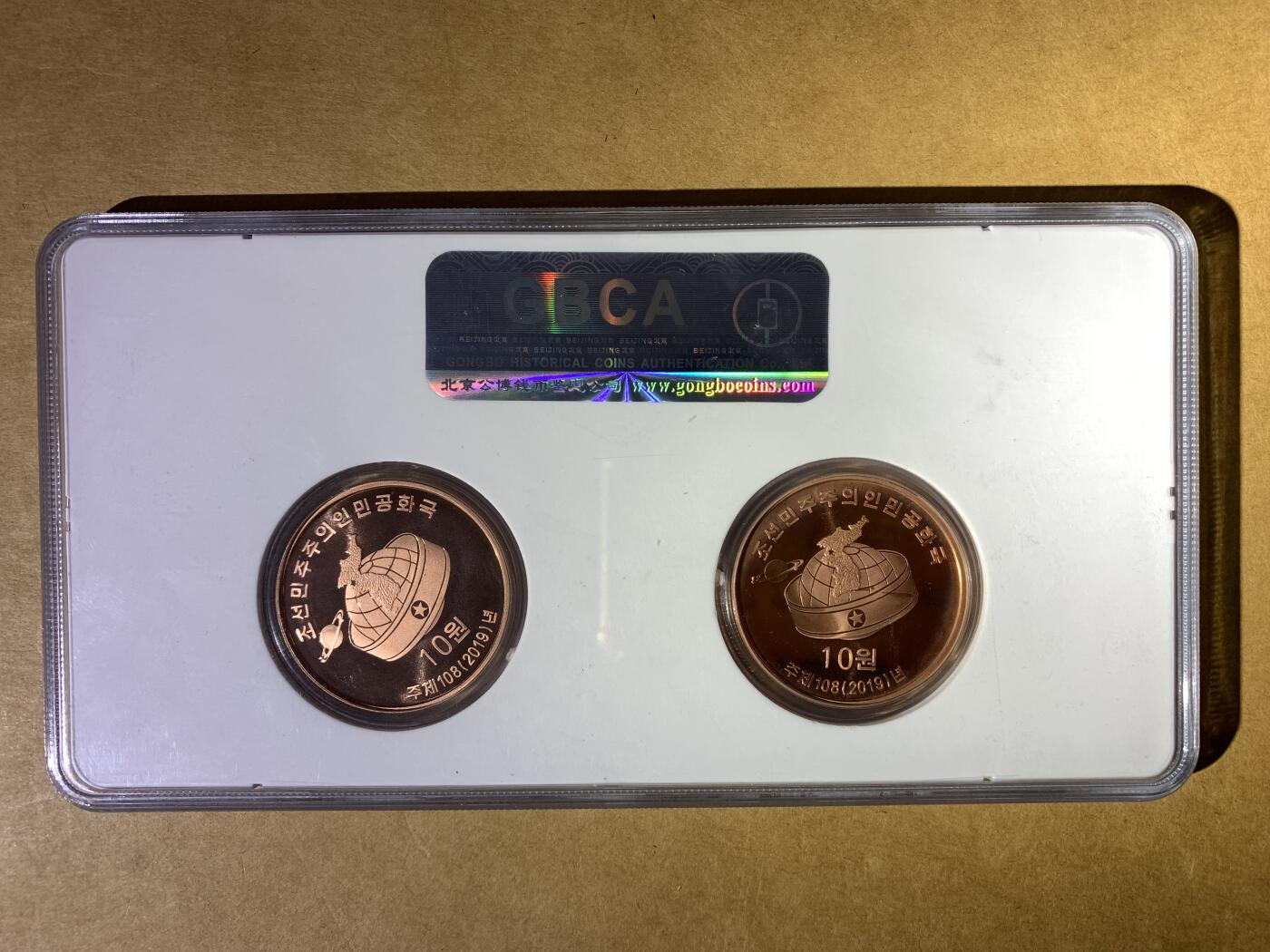 【礼羽收藏】🌏世界钱币拍卖第132期 2019年朝鲜的“保卫领袖”纪念币套装，包含两枚紫铜币，主题分别是“保卫领袖”和“党创建纪念馆”，都是MS69评级，品相完美。