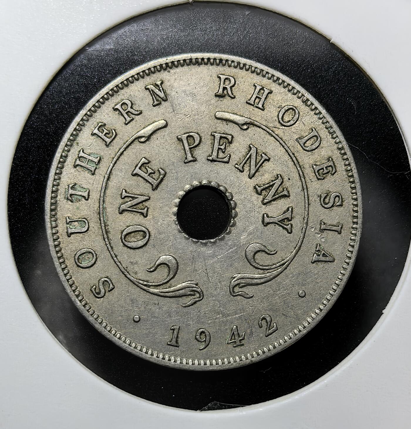 外国优质老铜币纪念币银币专场，周六晚上九点倒数截拍，满百包邮，周日发货,可寄存半年，喜欢朋友微信扫描二维码可直接参拍 南罗得西亚1942 年 1 便士圆孔币，发行于英属南罗得西亚时期，正面为乔治六世国王像，背面以圆孔与殖民地名标注面值，是二战期间英属非洲殖民地的流通辅币，承载英国殖民非洲、南罗得西亚（今津巴布韦）近代货币史
