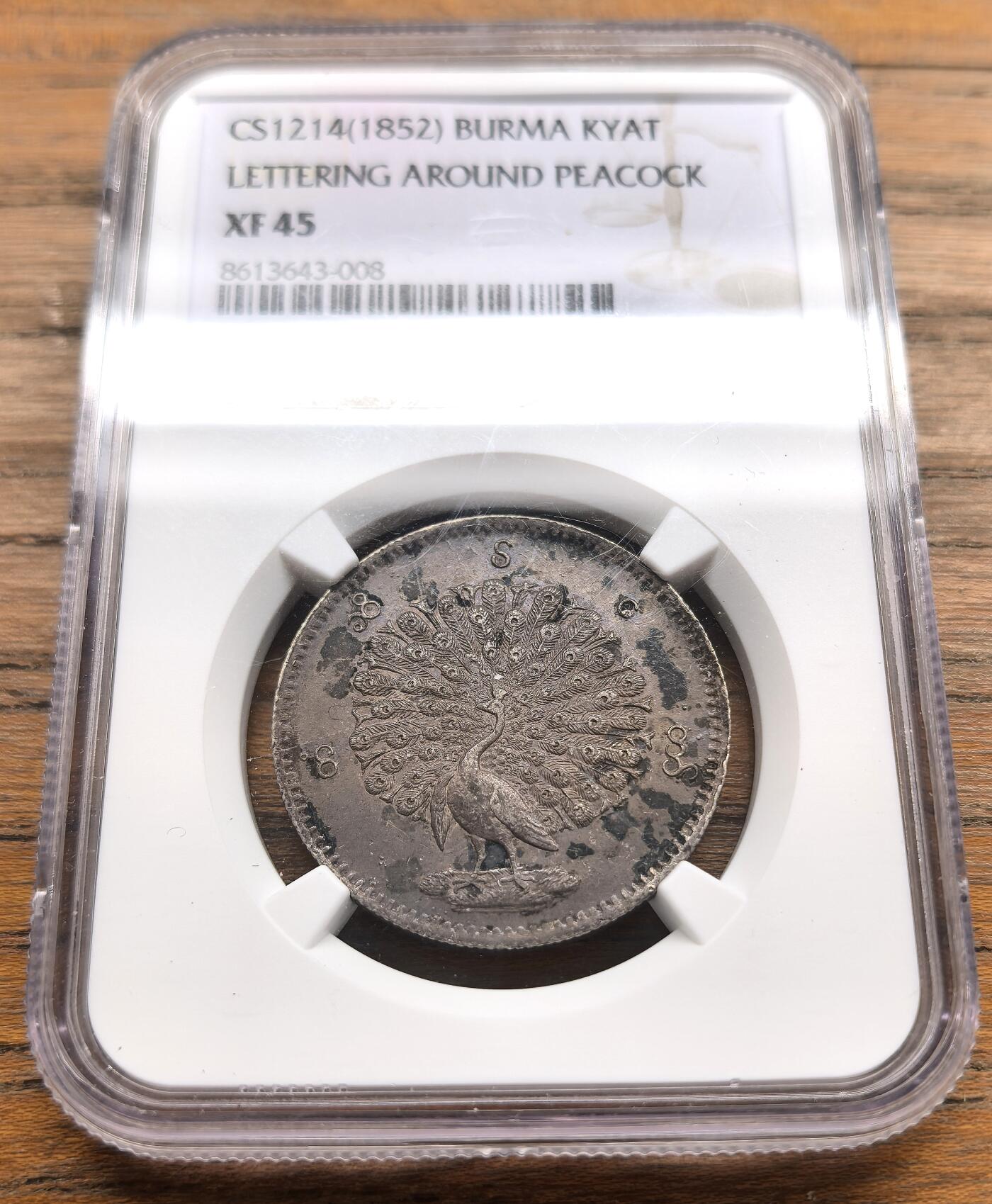 凡希社世界钱币微拍第三百二十二期 1852缅甸孔雀KYAT银币NGC-XF45，深色蓝紫油润彩，孔雀羽毛和眼睛细节相当出色，原味品，实物相当诱人的一枚！