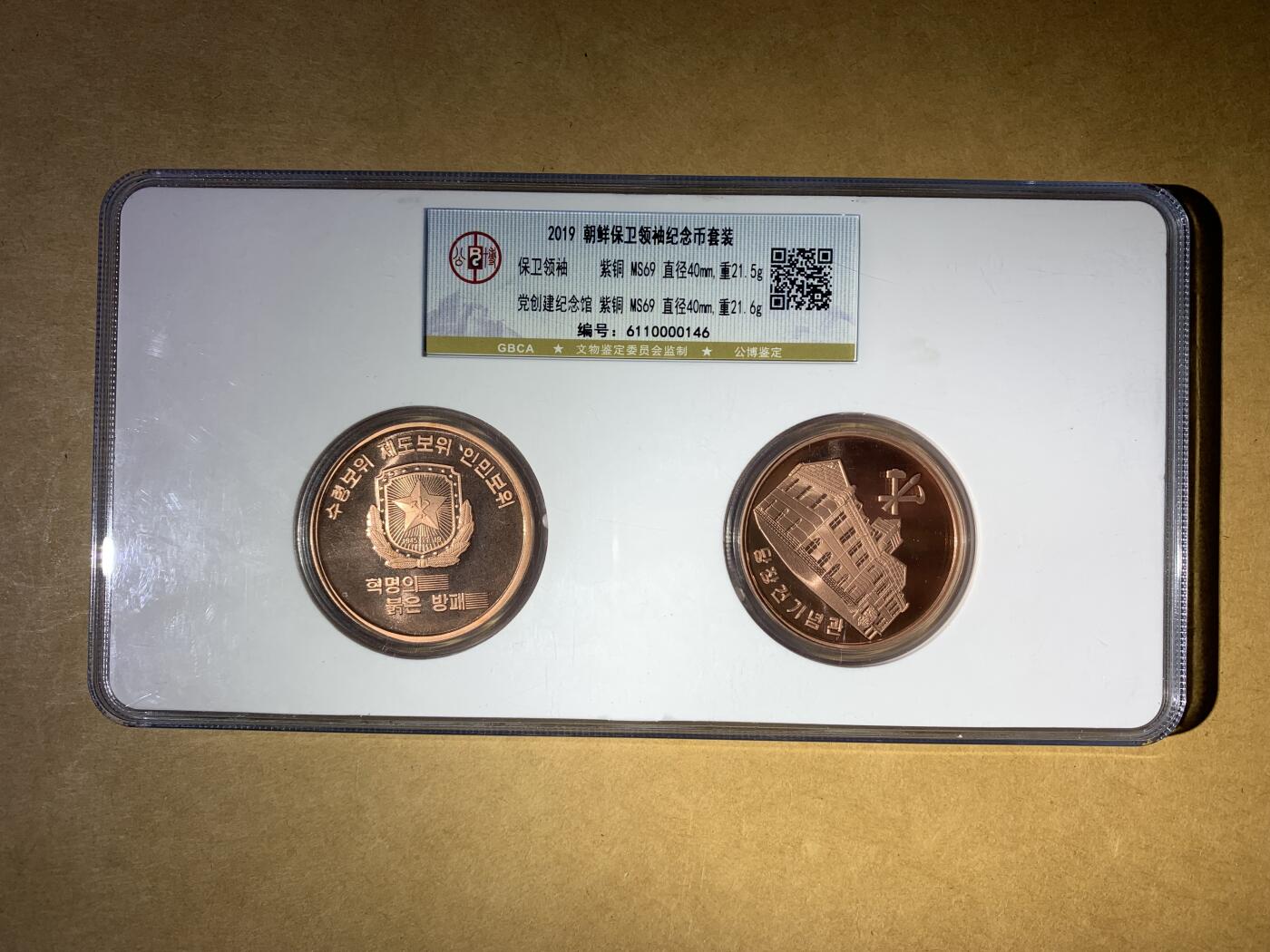 【礼羽收藏】🌏世界钱币拍卖第132期 2019年朝鲜的“保卫领袖”纪念币套装，包含两枚紫铜币，主题分别是“保卫领袖”和“党创建纪念馆”，都是MS69评级，品相完美。