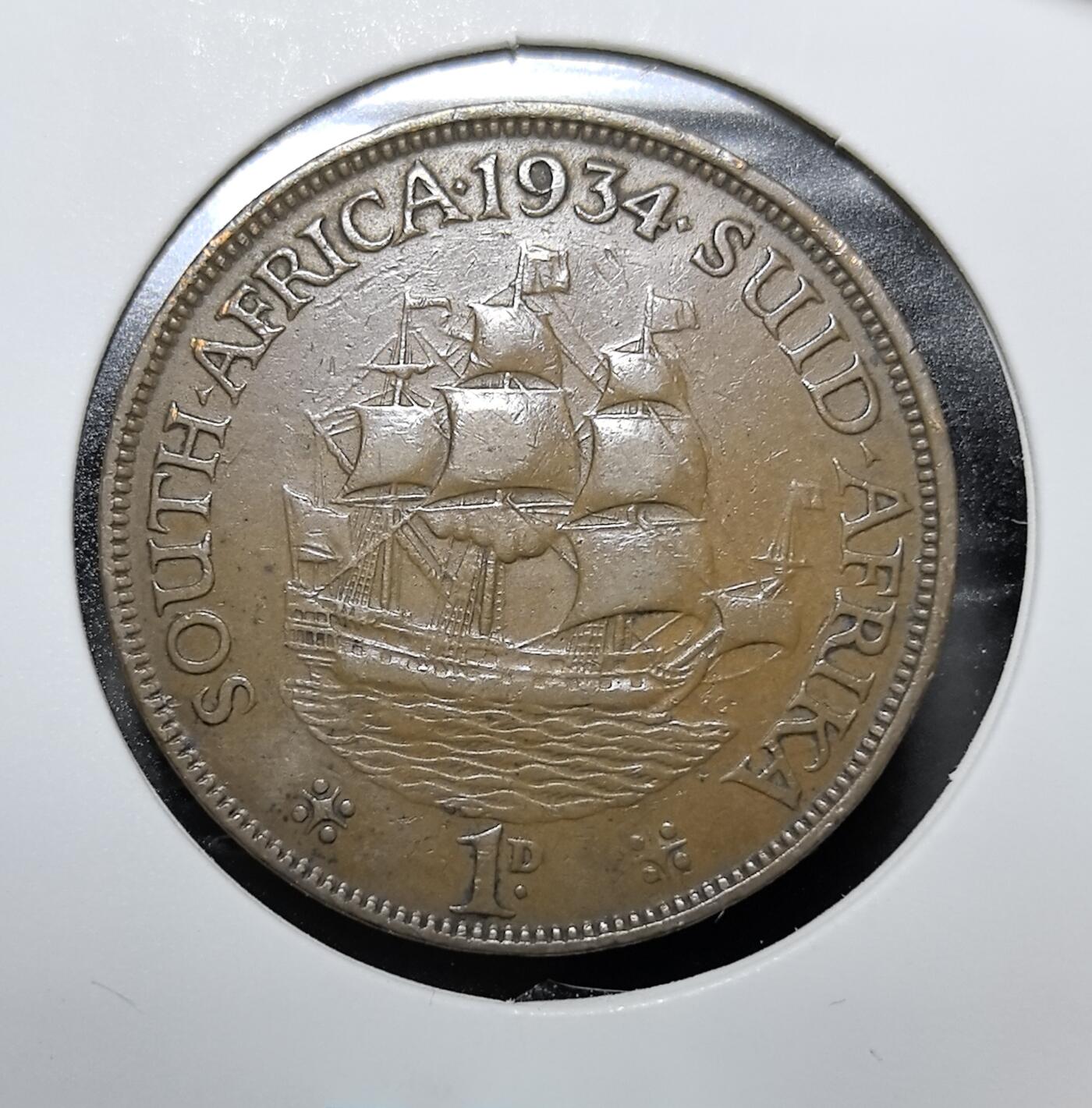外国优质老铜币纪念币银币专场，周六晚上九点倒数截拍，满百包邮，周日发货,可寄存半年，喜欢朋友微信扫描二维码可直接参拍 南非1934年1便士铜币，发行于乔治五世统治时期，双语铭文体现南非英裔与阿非利卡裔的双重文化背景，金鹿号帆船是南非殖民航海史的象征。该币是南非联邦建立后统一货币体系的核心实物，见证了英属南非的殖民统治与南非国家认同的形成。