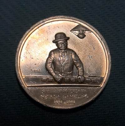 外国优质老铜币纪念币银币专场，周六晚上九点倒数截拍，满百包邮，周日发货,可寄存半年，喜欢朋友微信扫描二维码可直接参拍 - 庆祝内华达州赌博合法化 50 周年纪念章。1931 年正值美国大萧条时期，内华达州经济陷入困境，通过立法开放博彩业以刺激经济，这一举措直接催生了拉斯维加斯和雷诺等城市的繁荣，最终使其成为世界闻名的娱乐博彩中心。币面上的荷官形象生动还原了当时的博彩场景，背面的州徽则象征了州政府的权威与历史地位。