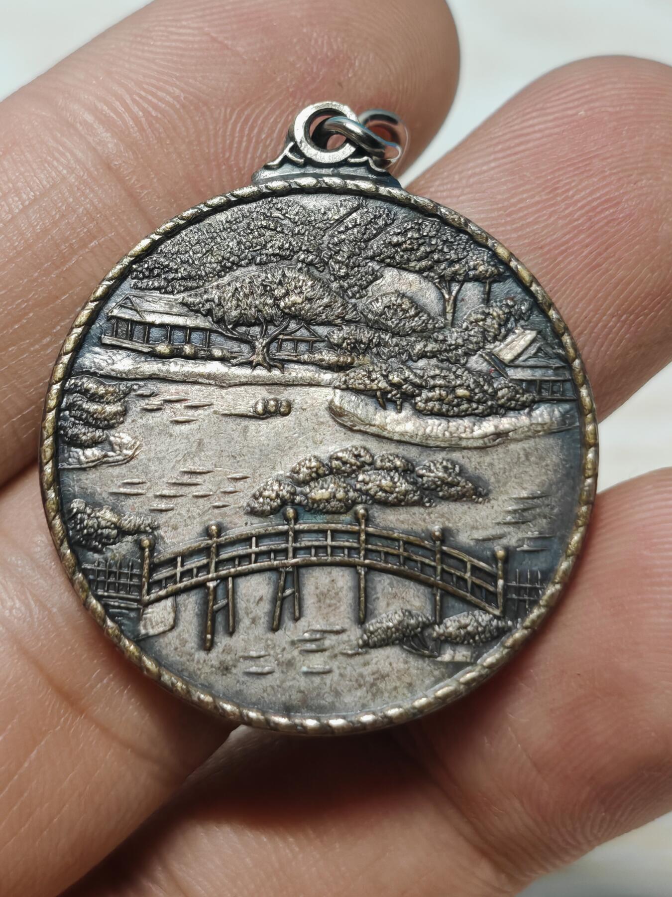 日本香川县高松市栗林公园观光纪念章，铜质，直径约32.3mm，正面“栗林公园 高松”，以及栗林公园最标志性的元素——园内有超过1400棵精心修剪的松树，背面公园风景浮雕，整体成色还可以，有正常使用痕迹，无明显磕碰。适合钱币、纪念章收藏