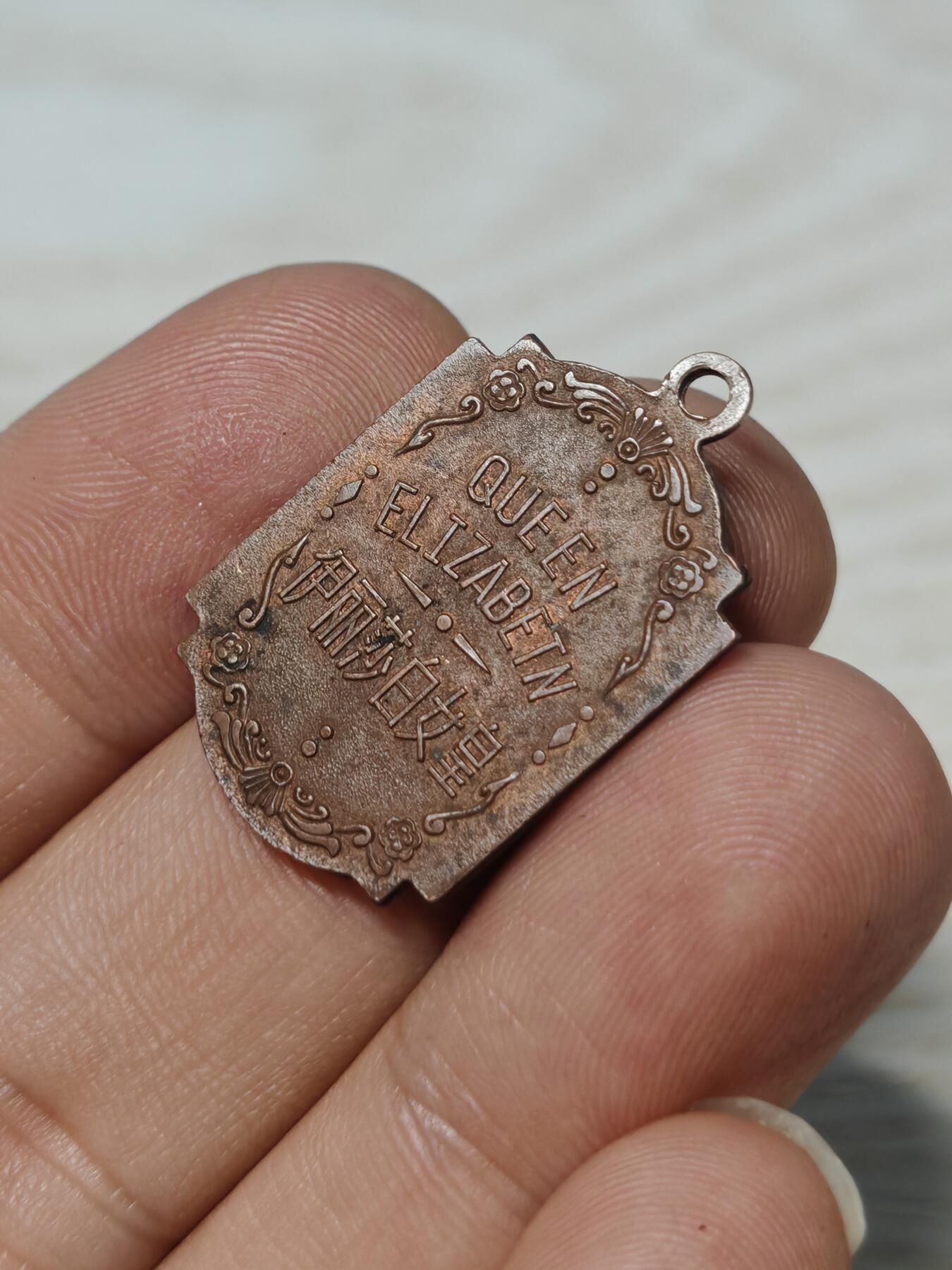 英国伊丽莎白女皇纪念章，铜质，双面浮雕，正面女王侧面像，背面QUEEN ELIZABETH及中文“伊丽莎白女皇”。尺寸约2.8cm*2cm，保存状态以图为准，有正常年代感，适合收藏