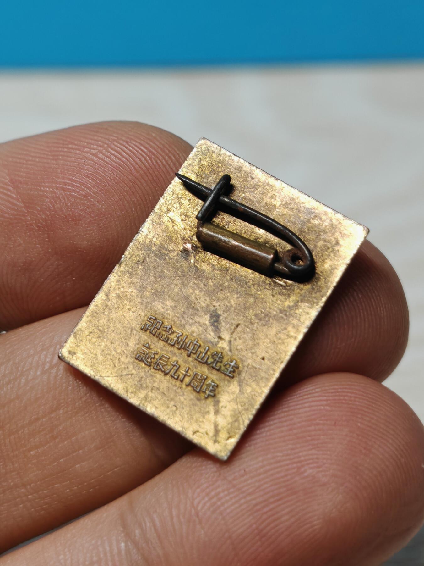 1956年纪念孙中山先生诞辰90周年铜鎏金纪念章徽章，黄铜鎏金材质，人物肖像錾刻立体清晰，背面有铭文。长2.5厘米，宽1.8厘米