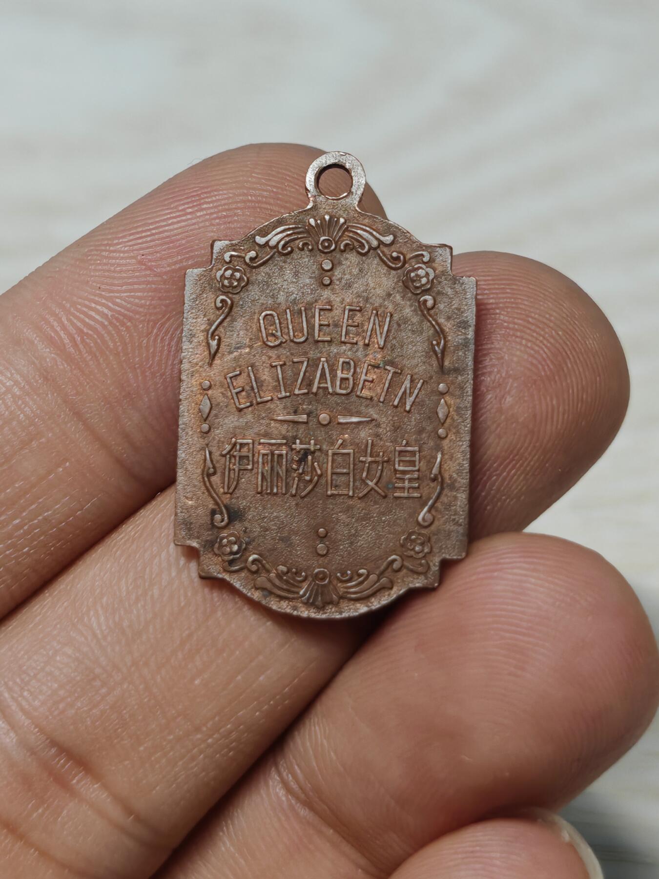 英国伊丽莎白女皇纪念章，铜质，双面浮雕，正面女王侧面像，背面QUEEN ELIZABETH及中文“伊丽莎白女皇”。尺寸约2.8cm*2cm，保存状态以图为准，有正常年代感，适合收藏