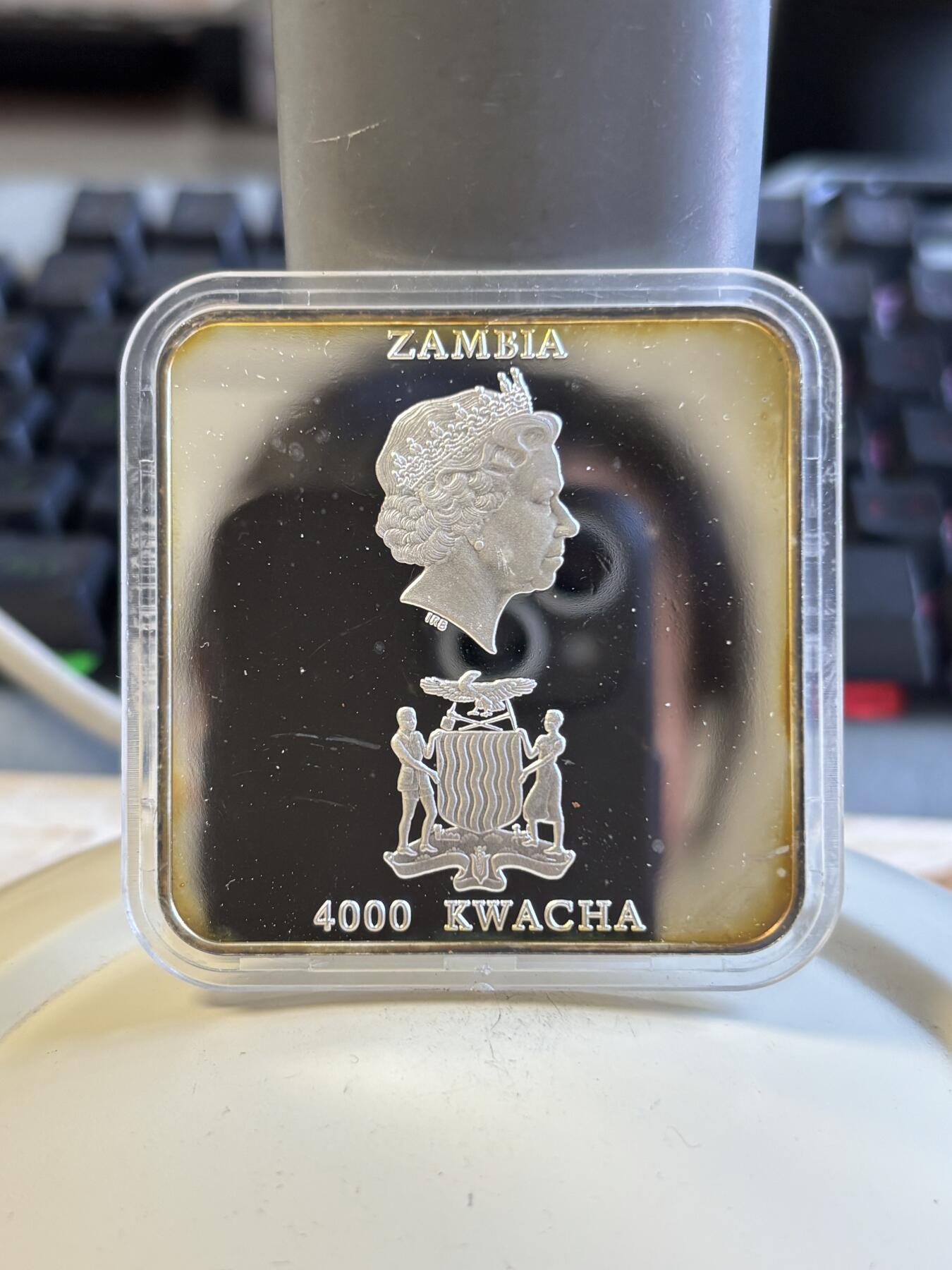 第197期拍卖 赞比亚2001年抽象画橱窗里的猫方型精制纪念银币，50克，999银，发行5000枚，塑料盒有瑕疵，币有氧化