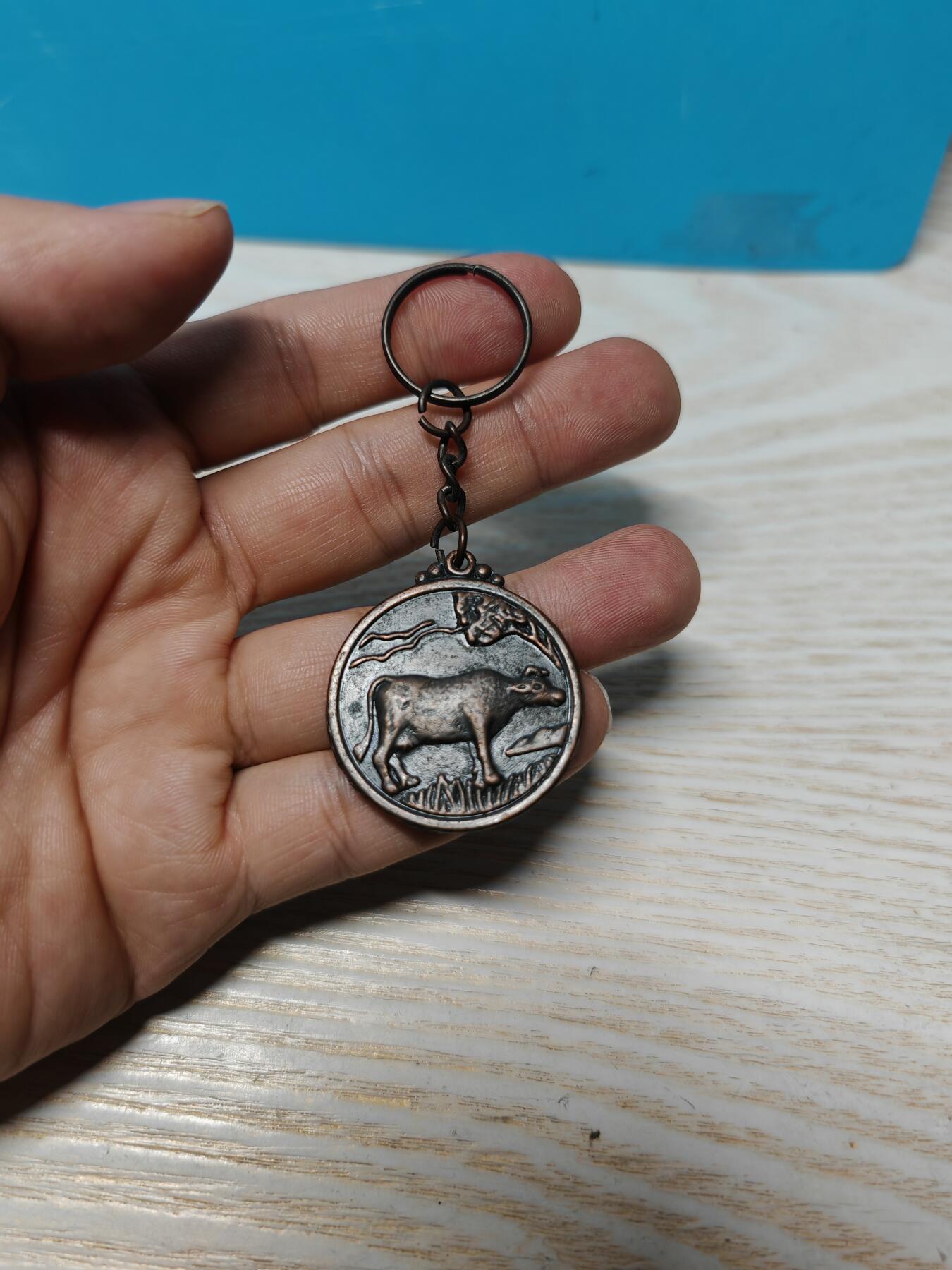 老生肖牌一枚，铜质，正面牛图案，背面十二生肖 八卦太极，带钥匙扣。直径约3.5厘米，成色还可以，有使用痕迹，无裂痕，细节见图。适合收藏或把玩