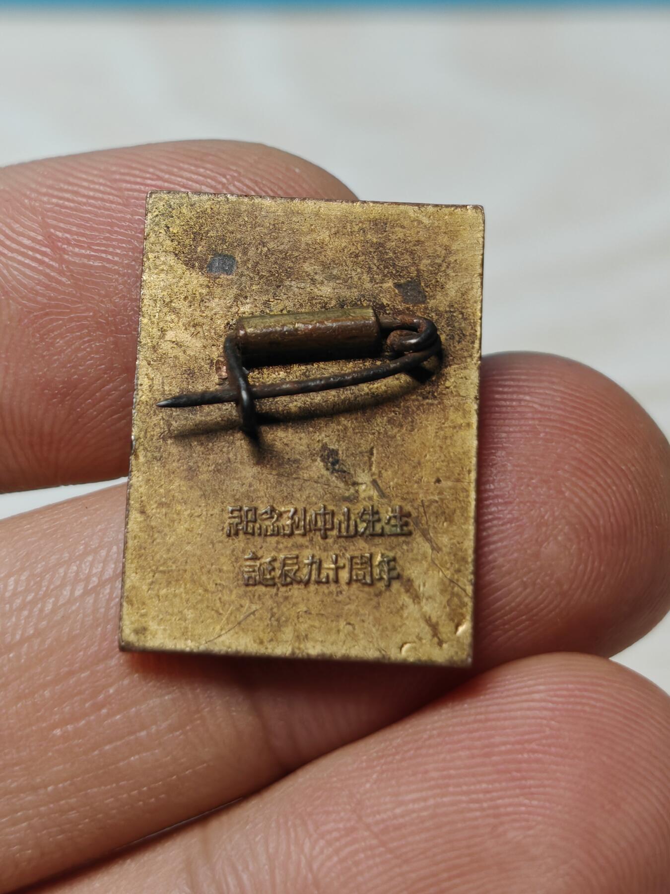 1956年纪念孙中山先生诞辰90周年铜鎏金纪念章徽章，黄铜鎏金材质，人物肖像錾刻立体清晰，背面有铭文。长2.5厘米，宽1.8厘米