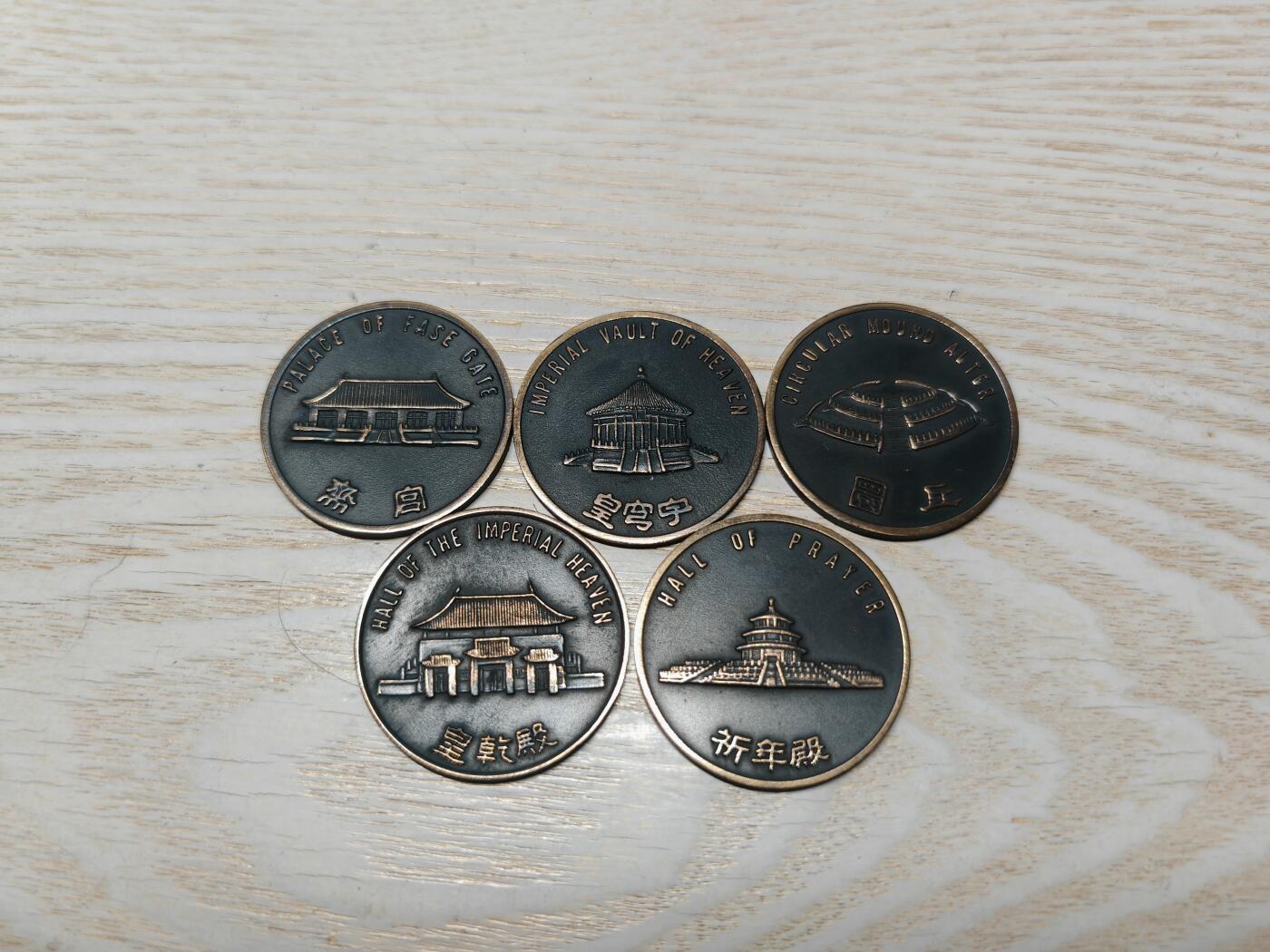 北京天坛系列纪念章一套5枚，铜质，直径约3.78cm，正面天坛祈年殿、皇穹宇、皇乾殿等建筑，背面有“坛门管理处”字样。整体品相几乎全新，保存较好，值得收藏。