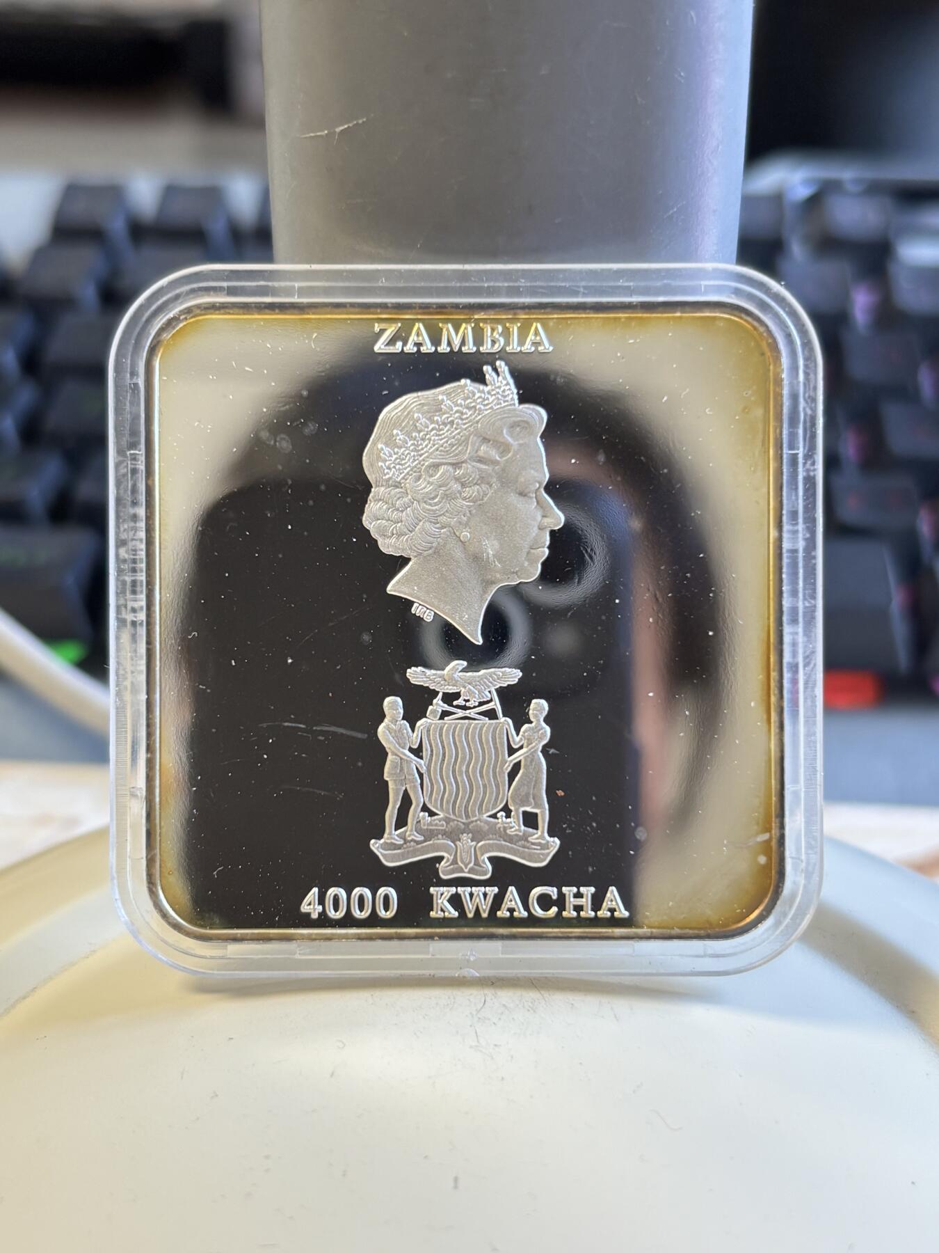 第197期拍卖 赞比亚2001年抽象画橱窗里的猫方型精制纪念银币，50克，999银，发行5000枚，塑料盒有瑕疵，币有氧化