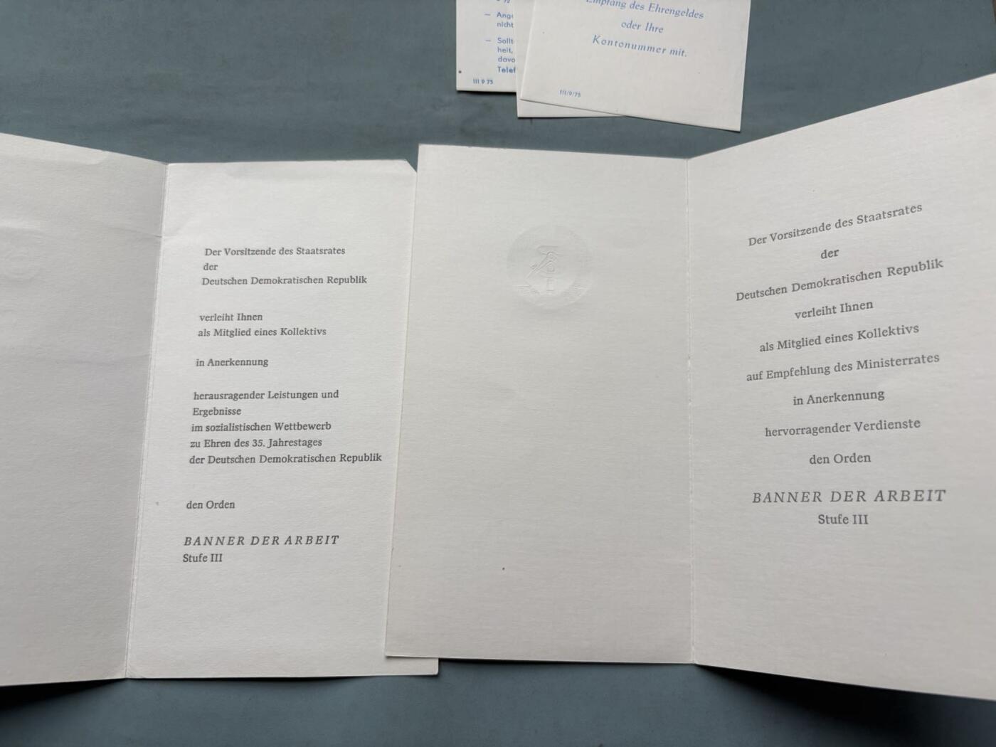 盛世勋华——号角文化勋章邮票专场拍卖第314期 东德1984年建国35周年，三级劳动红旗勋章全套授勋文件，含证书、邀请函及官方通知，包括2份主题邀请函（35周年国庆版、国徽版）3份仪式说明/须知文件