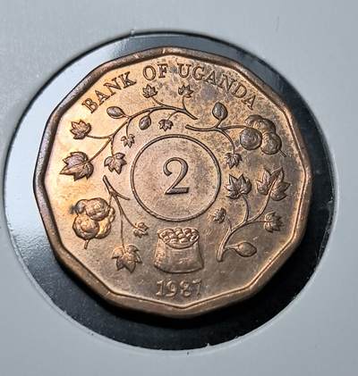 外国优质老铜币纪念币银币专场，周六晚上九点倒数截拍，满百包邮，周日发货,可寄存半年，喜欢朋友微信扫描二维码可直接参拍 - 乌干达1987年2 先令，正面为乌干达国徽，背面绘棉花枝与棉袋，彰显其支柱农业经济，是乌干达独立后本土流通货币，见证其经济与货币主权发展。