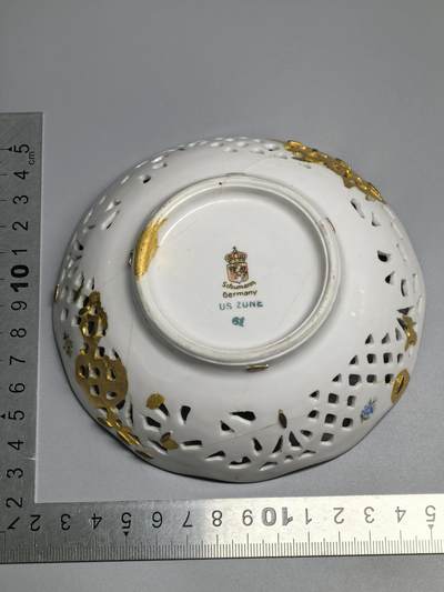 小驴勋章奖章收藏4月18日周六晚六点拍卖（珍爱和平，收藏战争，铭记历史，勿忘国耻，忠党爱国。有偿代拍，送拍规则在简介最后，参拍须阅读规则后再参拍，关系到运费包装发货时效真假辨别等关键信息，拍卖时不再发原图，看大图店主微信码在拍卖店铺介绍里或者找我要） 德国占领区镂空瓷碗 高4厘米，直径12.5厘米。 德国1945年左右苏曼镂空瓷碗，美军占领区款印。战争末期的占领款印稀少，有正常的历史修补痕迹。跟咱锔瓷器差不多