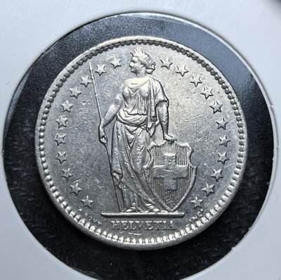 外国优质老铜币纪念币银币专场，周六晚上九点倒数截拍，满百包邮，周日发货,可寄存半年，喜欢朋友微信扫描二维码可直接参拍 - 瑞士1981年2法郎流通币。正面为瑞士守护女神海尔维蒂亚（Helvetia）持矛持盾形象，环绕五角星；背面为橡叶花环与面值，是瑞士经典的联邦币。