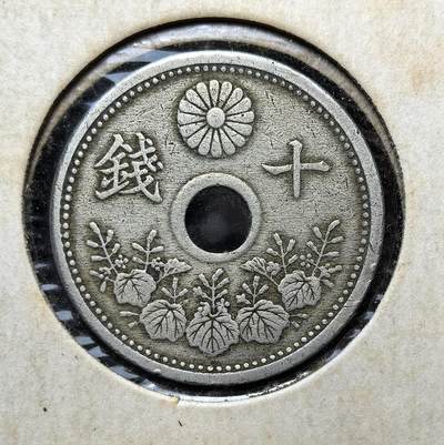 外国优质老铜币纪念币银币专场，周六晚上九点倒数截拍，满百包邮，周日发货,可寄存半年，喜欢朋友微信扫描二维码可直接参拍 - 日本大正十一年（1922 年）十钱白铜穿孔币，属大正时期流通辅币，正面饰桐叶与菊纹，背面为波浪纹，是日本近代货币体系的典型代表，见证了大正时代的经济与社会风貌。