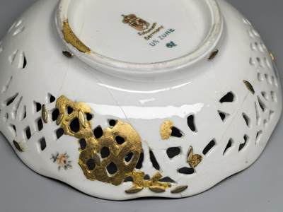 小驴勋章奖章收藏4月18日周六晚六点拍卖（珍爱和平，收藏战争，铭记历史，勿忘国耻，忠党爱国。有偿代拍，送拍规则在简介最后，参拍须阅读规则后再参拍，关系到运费包装发货时效真假辨别等关键信息，拍卖时不再发原图，看大图店主微信码在拍卖店铺介绍里或者找我要） 德国占领区镂空瓷碗 高4厘米，直径12.5厘米。 德国1945年左右苏曼镂空瓷碗，美军占领区款印。战争末期的占领款印稀少，有正常的历史修补痕迹。跟咱锔瓷器差不多