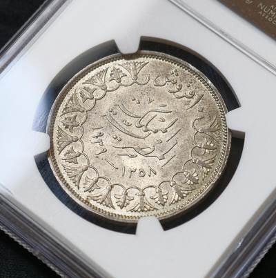 甄臻铺-世界币章拍卖（第60期），甄品场拍品征集中，送拍享返佣金等优惠多多 NGC-MS63 1939年埃及法鲁克国王10皮阿斯特银币，正面刻有法鲁克国王头像，背面阿拉伯文和花卉装饰，品相完好，包浆自然