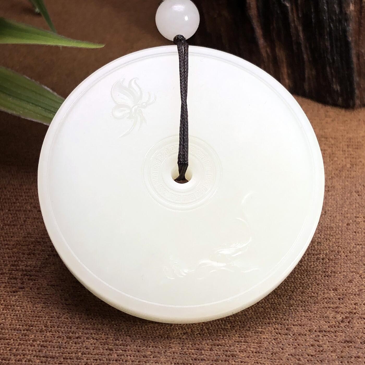 平安大扣子脂白新疆和田玉作品，平安扣，58.63g，直径51，白皮，玉质油润，脂粉感十足，糯性满满，微微结构，双面浮雕工艺，古朴大气，海派玉雕名家作品，有款证全套包装！JL310416