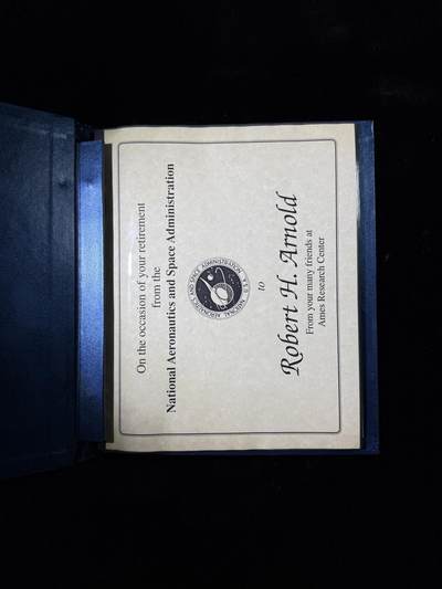 戎马世界章牌大赏第115期 美国证书套，属于柯伊柏机载天文台负责人Robert H. Arnold，他曾作为航空电子技术人员在美国海军服役，后转到美国空军，继续从事飞机航空电子设备专业相关工作。1968年从部队退役后在艾姆斯研究中心（Ames Research Center）工作，担任柯伊伯空中天文台（KAO）负责人，参与了一系列的科学发现，包括天王星存在光环、冥王星周围的大气和星际介质中存在水蒸气等