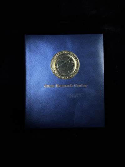 戎马世界章牌大赏第115期 美国证书套，属于柯伊柏机载天文台负责人Robert H. Arnold，他曾作为航空电子技术人员在美国海军服役，后转到美国空军，继续从事飞机航空电子设备专业相关工作。1968年从部队退役后在艾姆斯研究中心（Ames Research Center）工作，担任柯伊伯空中天文台（KAO）负责人，参与了一系列的科学发现，包括天王星存在光环、冥王星周围的大气和星际介质中存在水蒸气等