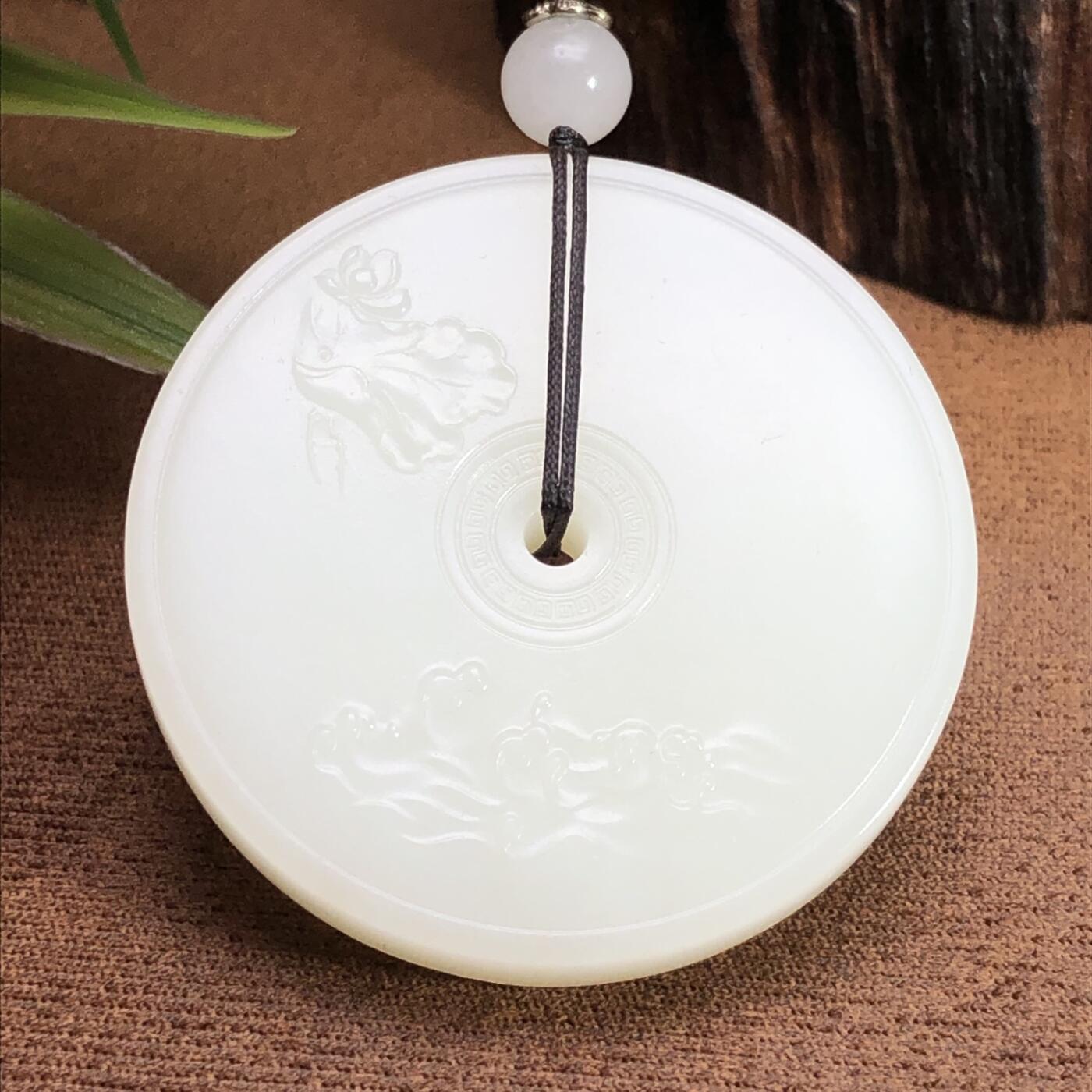 平安大扣子脂白新疆和田玉作品，平安扣，58.63g，直径51，白皮，玉质油润，脂粉感十足，糯性满满，微微结构，双面浮雕工艺，古朴大气，海派玉雕名家作品，有款证全套包装！JL310416