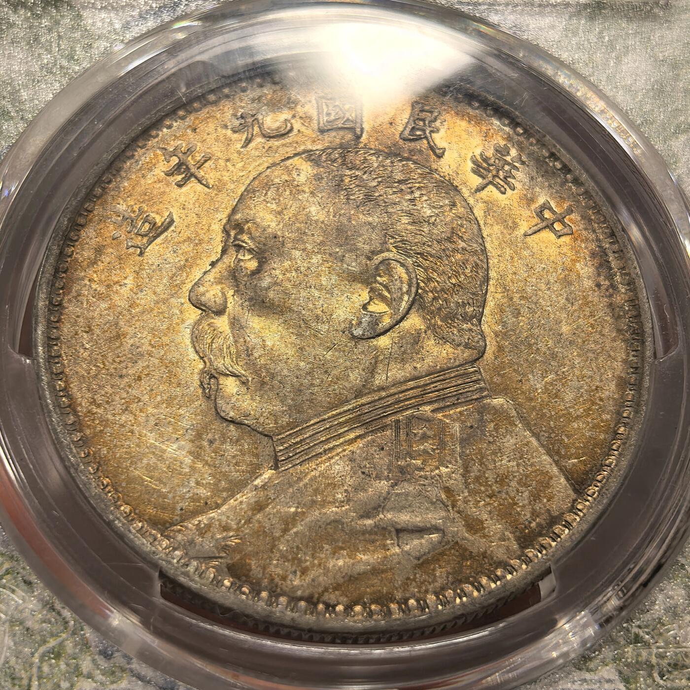 博洋堂世界钱币拍卖第168期（全场包邮） PCGS AU53 中华民国九年袁像一元银币，精发版配风云盒，人像面是非常漂亮的金黄彩，背面异常惊艳的酒红色酱五彩，人物文字和嘉禾深打，钢丝发，眼眶颧骨高挺，胡须根根分明，这种彩出分非常不容易，在pcgs万里挑一，大多9194，一枚入藏直接到位。pc同分白币九精现在都要卖到两千八了。