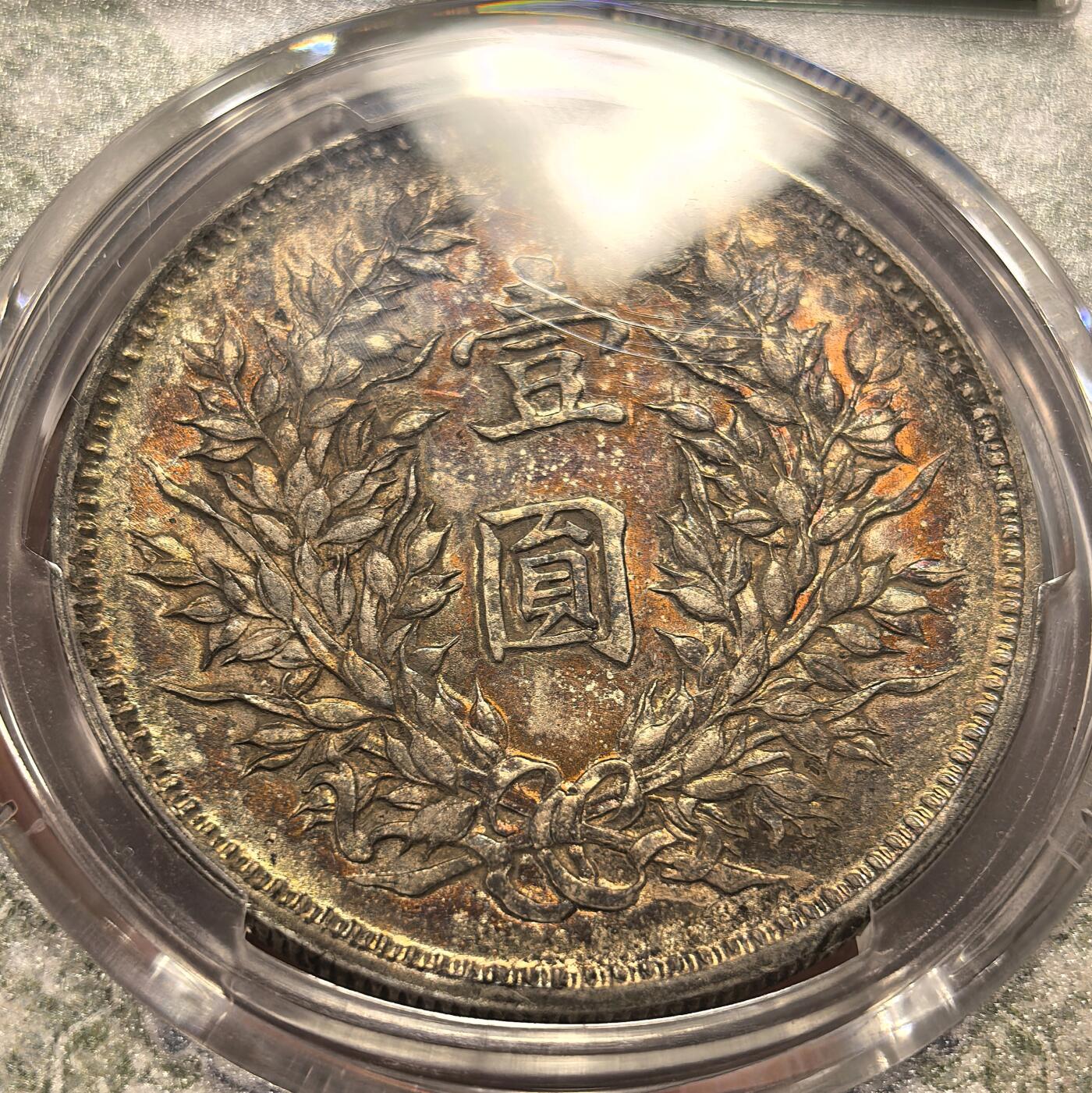 博洋堂世界钱币拍卖第168期（全场包邮） PCGS AU53 中华民国九年袁像一元银币，精发版配风云盒，人像面是非常漂亮的金黄彩，背面异常惊艳的酒红色酱五彩，人物文字和嘉禾深打，钢丝发，眼眶颧骨高挺，胡须根根分明，这种彩出分非常不容易，在pcgs万里挑一，大多9194，一枚入藏直接到位。pc同分白币九精现在都要卖到两千八了。