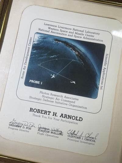 戎马世界章牌大赏第115期 美国证书套，属于柯伊柏机载天文台负责人Robert H. Arnold，他曾作为航空电子技术人员在美国海军服役，后转到美国空军，继续从事飞机航空电子设备专业相关工作。1968年从部队退役后在艾姆斯研究中心（Ames Research Center）工作，担任柯伊伯空中天文台（KAO）负责人，参与了一系列的科学发现，包括天王星存在光环、冥王星周围的大气和星际介质中存在水蒸气等