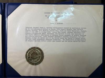 戎马世界章牌大赏第115期 美国飞行员衣服与空军嘉奖以及服役功绩奖章证书一套，获得事迹分别为保障联队从F-4鬼怪到F-16战隼的平稳换装转型以及在担任驻英国本特沃特斯第81战术战斗机联队生命保障主管期间以极强专业能力保障战机完好率，所属单位获评驻欧空军年度最优，为美国空军赢得重大荣誉