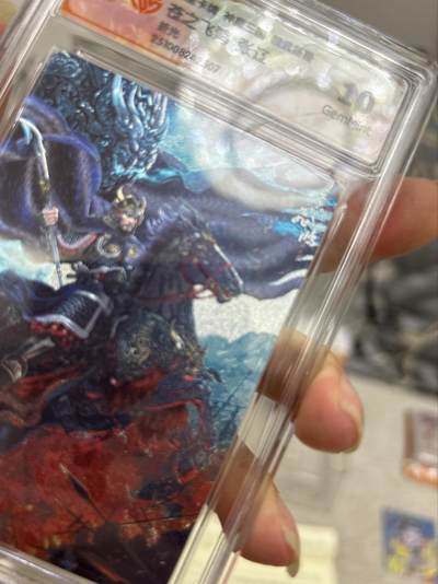 喜灰玩卡拍卖第八期，接拍品0佣金，欢迎送拍，释放现金流，让自己有资金可以购买更多喜欢的卡牌，让别的卡友能淘到更多心仪的卡牌 百里 神魔三国 飞鸿老师绘 张辽 折光 （评级壳有磨痕介意勿拍）