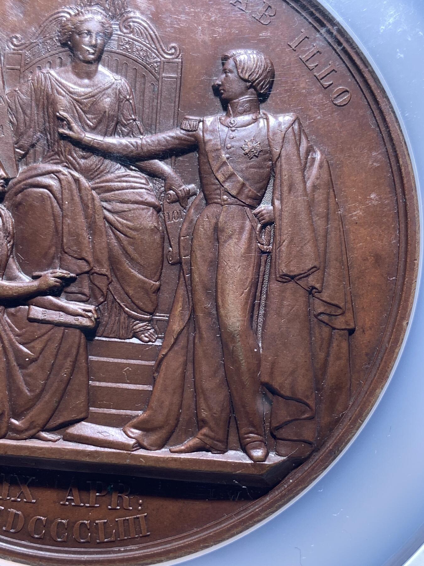 《竞宝斋》第481场 周日，周一 2场连拍 （全场包邮）20级店铺 欢迎送拍 NGC MS64BN 比利时1853年利奥波德二世成年宣誓制造大规格铜章，由著名章牌雕刻师Leopold Wiener设计制作（大名定鼎鼎），该章是王室章牌中的经典藏品。英国皇家收藏、法国国家图书馆、澳大利亚维多利亚馆均有收藏。可见盖该章的历史性和收藏价值。双面高浮雕，巧克力包浆，直径：75mm，重：175g，加大加厚盒装。