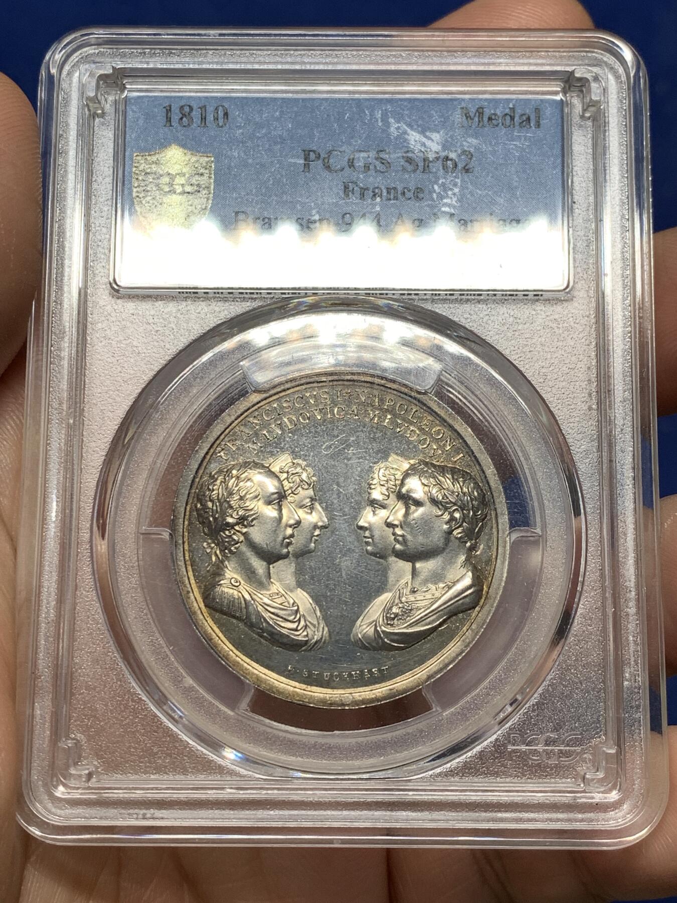 《竞宝斋》第481场 周日，周一 2场连拍 （全场包邮）20级店铺 欢迎送拍 少见 PCGS SP62 拿破仑一世原铸银章 1810年拿破仑一世与玛丽·路易丝皇室婚礼纪念银章 正面为拿破仑一世与玛丽·路易丝，以及玛丽·路易丝的父母奥地利皇帝弗朗茨一世与皇后玛丽亚·特蕾西亚，强调这场婚姻所连接的法兰西帝国与哈布斯堡王朝之间的政治联盟关系。背面描绘罗马神话中的“协和女神”手持两只巨大的丰饶之角，象征和谐、联盟与国家秩序。难得一见的拿破仑原铸银章。