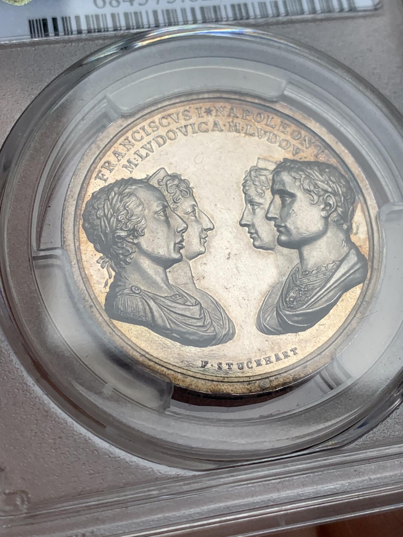 《竞宝斋》第481场 周日，周一 2场连拍 （全场包邮）20级店铺 欢迎送拍 少见 PCGS SP62 拿破仑一世原铸银章 1810年拿破仑一世与玛丽·路易丝皇室婚礼纪念银章 正面为拿破仑一世与玛丽·路易丝，以及玛丽·路易丝的父母奥地利皇帝弗朗茨一世与皇后玛丽亚·特蕾西亚，强调这场婚姻所连接的法兰西帝国与哈布斯堡王朝之间的政治联盟关系。背面描绘罗马神话中的“协和女神”手持两只巨大的丰饶之角，象征和谐、联盟与国家秩序。难得一见的拿破仑原铸银章。