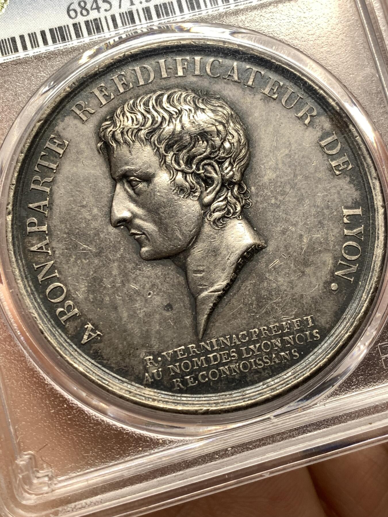 《竞宝斋》第481场 周日，周一 2场连拍 （全场包邮）20级店铺 欢迎送拍 少见 PCGS SP58 拿破仑一世原铸银章 1800年法国银质纪念章 拿破仑一世·里昂重建与马伦哥战役纪念 正面刻画拿破仑·波拿巴侧面肖像，环绕铭文“BONAPARTE RÉDIFICATEUR DE LYON”，意为“重建里昂的波拿巴”，背面以橡叶与月桂叶花环环绕长段铭文，记述拿破仑在马伦哥战役中取胜、再次征服意大利，并于共和国八年雾月（1800年）以第一执政身份下令重建里昂贝勒库尔广场（Pl