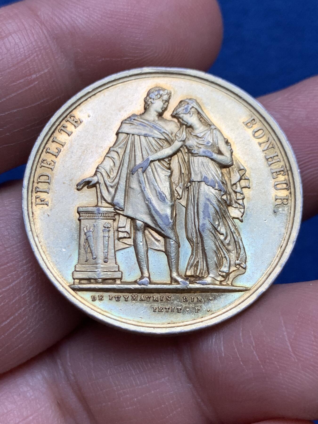 《竞宝斋》第482场 周日，周一 2场连拍 （全场包邮）20级店铺 欢迎送拍 1829年法国新古典主义风格婚礼纪念镀金银章，由Depaulis与Petit两位大师合作制造，正面刻画了新婚夫妇相拥场景，边缘铭文译“忠诚、幸福“，底部双大师签名，背面桂叶花环代表荣誉与永恒，结合花环寓意婚姻珍贵长久。直径：32.7mm，重：15.2g