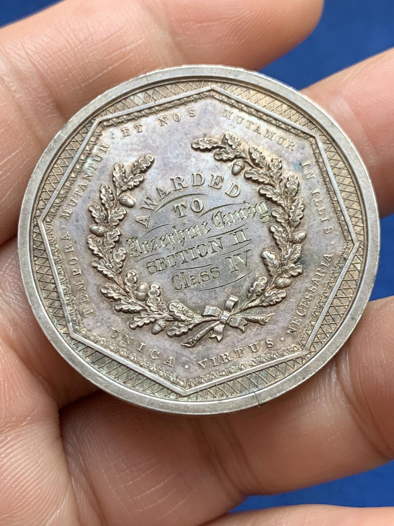 《竞宝斋》第482场 周日，周一 2场连拍 （全场包邮）20级店铺 欢迎送拍 澳大利亚塔斯马尼亚霍巴特市工业展览会银质奖章，罕见的外圆内八造型。边有对孔（挂奖牌）。该章是澳大利亚殖民时期极具代表性的收藏品，极少见，历史价值高。由塔斯马尼亚政府及地方议会主办制造。正面图案：描绘了象征霍巴特的拟人化形象坐于祭坛之上，手持花环。铭文译：以此为基，霍巴特日益强盛。背面 拉丁文箴言译为：时代在变，我们亦随之改变；唯有美德（或技艺）是不可或缺的。直径：38.3m，24.6克。