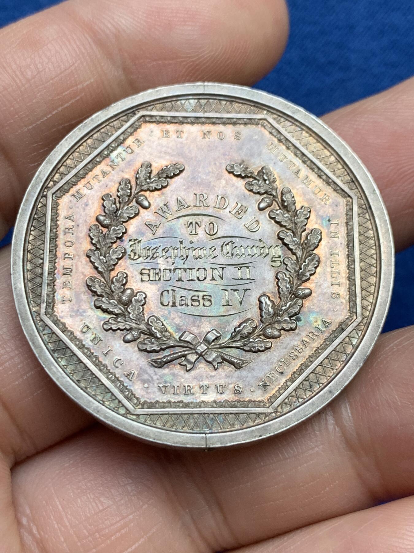 《竞宝斋》第482场 周日，周一 2场连拍 （全场包邮）20级店铺 欢迎送拍 澳大利亚塔斯马尼亚霍巴特市工业展览会银质奖章，罕见的外圆内八造型。边有对孔（挂奖牌）。该章是澳大利亚殖民时期极具代表性的收藏品，极少见，历史价值高。由塔斯马尼亚政府及地方议会主办制造。正面图案：描绘了象征霍巴特的拟人化形象坐于祭坛之上，手持花环。铭文译：以此为基，霍巴特日益强盛。背面 拉丁文箴言译为：时代在变，我们亦随之改变；唯有美德（或技艺）是不可或缺的。直径：38.3m，24.6克。