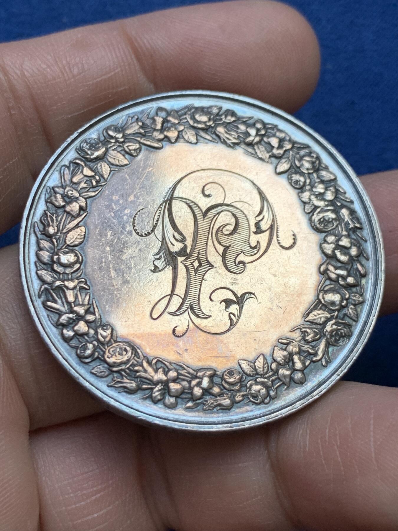 《竞宝斋》第482场 周日，周一 2场连拍 （全场包邮）20级店铺 欢迎送拍 1882年法国主题婚礼纪念大银章，带原盒。正面：刻画新人在基督教祭坛与十字架前宣誓的场景，边缘标注“MARIAGE”与“FIDELITE”，底部有“FRAISSE F.”雕刻师署名，背面：以玫瑰花环环绕花体字母组合，玫瑰象征爱情忠贞，花环设计强化婚姻圆满的寓意。直径：41.2mm，重：31.8g，蜜蜂银标。