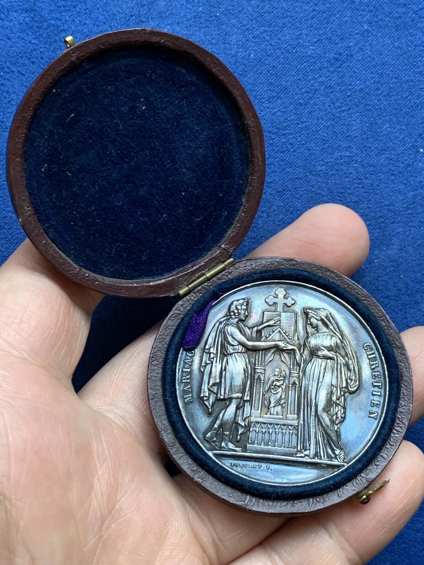 《竞宝斋》第482场 周日，周一 2场连拍 （全场包邮）20级店铺 欢迎送拍 1882年法国主题婚礼纪念大银章，带原盒。正面：刻画新人在基督教祭坛与十字架前宣誓的场景，边缘标注“MARIAGE”与“FIDELITE”，底部有“FRAISSE F.”雕刻师署名，背面：以玫瑰花环环绕花体字母组合，玫瑰象征爱情忠贞，花环设计强化婚姻圆满的寓意。直径：41.2mm，重：31.8g，蜜蜂银标。